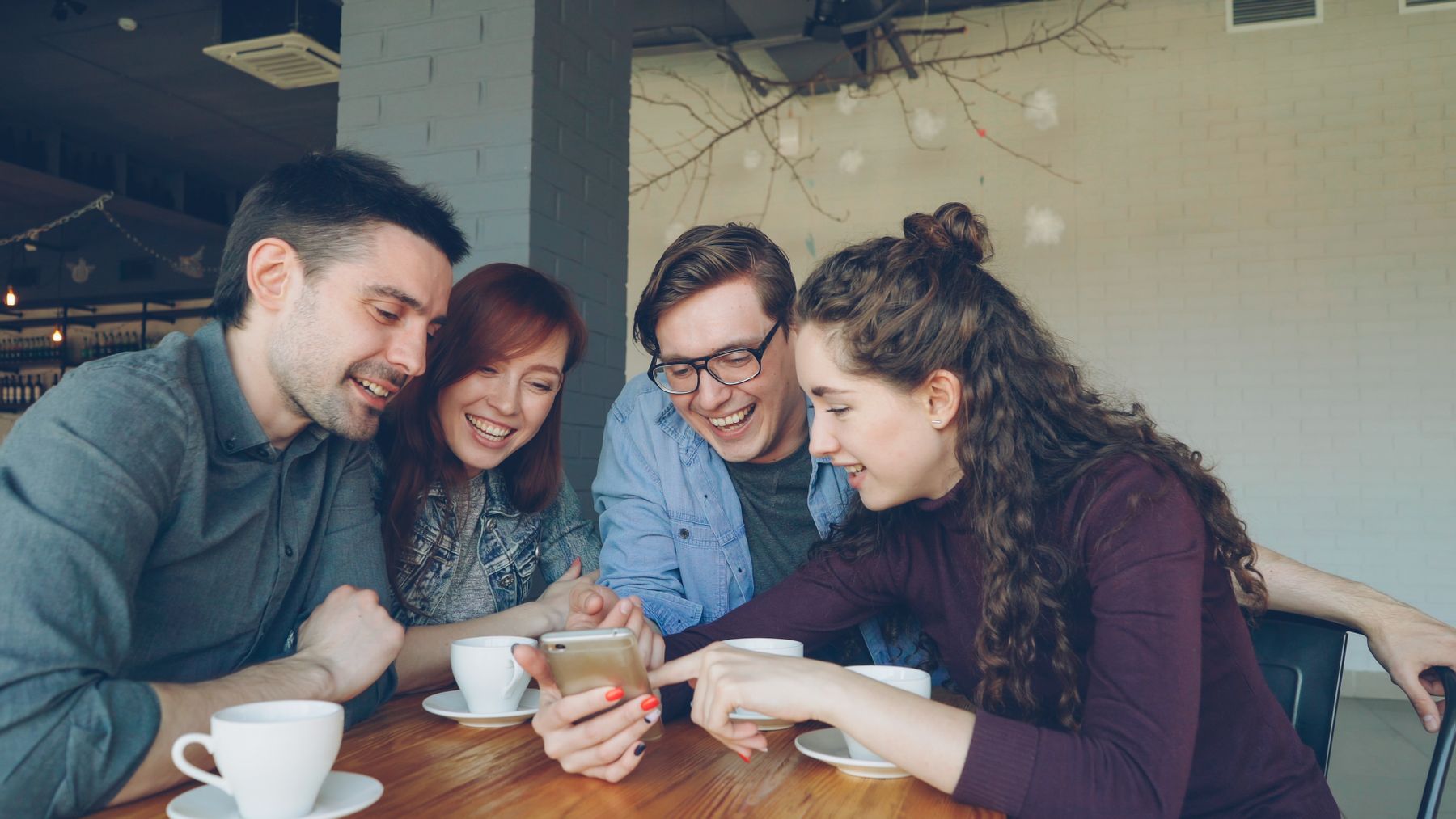 Junge Menschen nutzen gemeinsam ein Smartphone